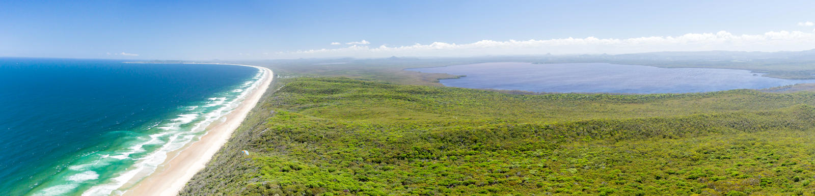 large forested sandhills separating the ocean and large lake