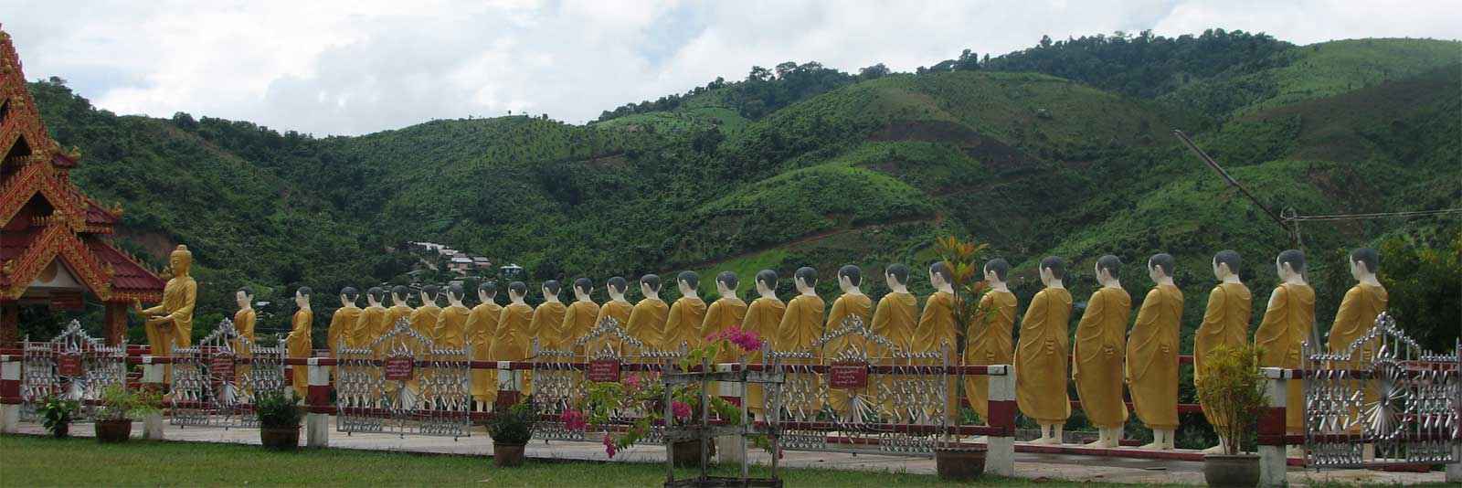 A row of tall gold Buddhist statues are on display at the beautiful Shwe Dagon Pagoda temple in Tachilek, Burma (Myanmar)
