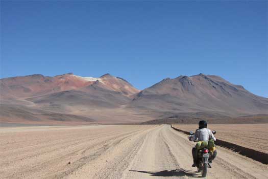 Chris riding over a desert in Bolivia