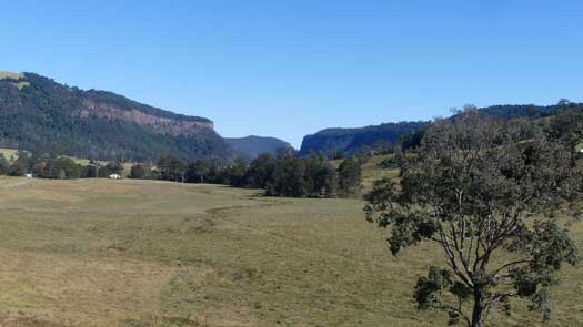Looking across paddocks to the gorge lined with cliffs and forested sections