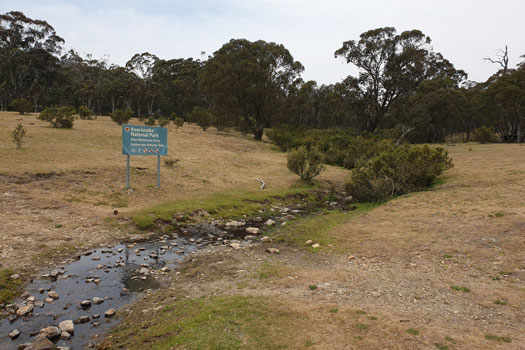 Sign at the small stream marking border.