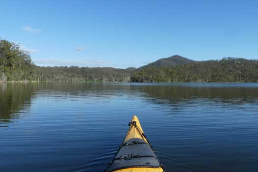 Kayak on a lake overlooking forested hillside